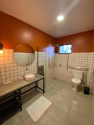 a bathroom with a toilet and a sink and a mirror at Pousada Primavera in Parnaíba