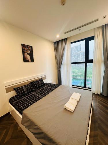 una camera da letto con un letto grande con una grande finestra di Vinhomes Grand Park the Beverly a Gò Công