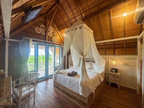 a bedroom with a canopy bed in a house at Hideout Sunset in Nusa Penida