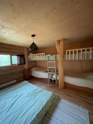 En eller flere senge i et værelse på Hébergement Mauricie, La Tuque