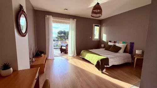 een slaapkamer met een bed en een glazen schuifdeur bij Chez Patricia et Georges in Carry-le-Rouet