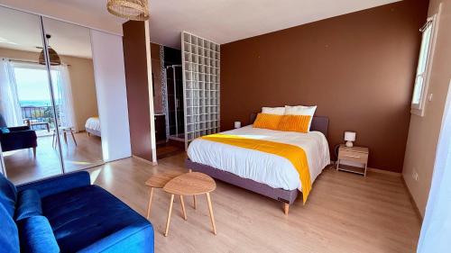 een slaapkamer met een kingsize bed en een blauwe bank bij Chez Patricia et Georges in Carry-le-Rouet