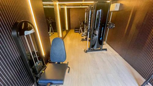 a gym with a blue chair in a room at W Tambaú Apart Hotel in João Pessoa