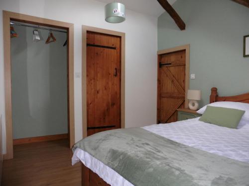 a bedroom with a bed with a green laptop on it at tillys Cottage in Folles