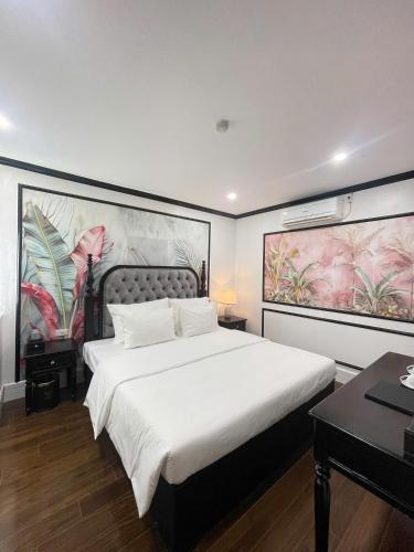 een slaapkamer met een groot bed met een groot schilderij aan de muur bij Diamond Hotel in Long Biên