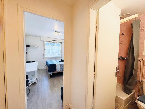 ein Zimmer mit einem Schlafzimmer mit einem Bett und einem Spiegel in der Unterkunft Studio pour 2 près de la gare in Melun