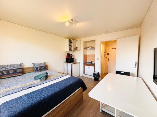 ein kleines Zimmer mit einem Bett und einem Tisch in der Unterkunft Studio pour 2 près de la gare in Melun
