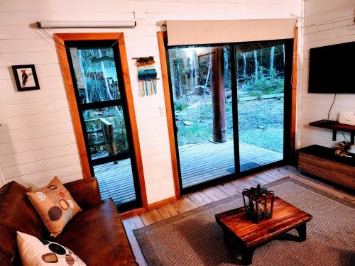 柯纳里佩Cabañas Alto del Bosque的客厅里有一张沙发和一台电视