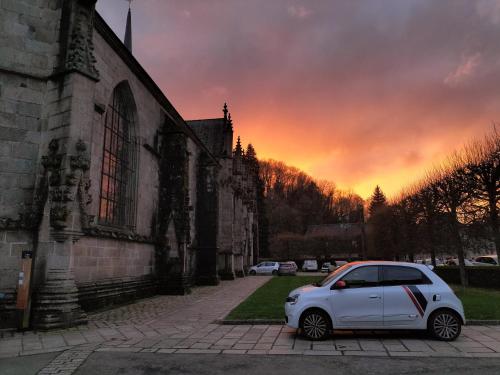 een witte auto geparkeerd voor een kerk bij L'Escapade Médiévale in Fougères