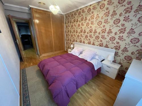 ein Schlafzimmer mit einem lila Bett in einem Zimmer in der Unterkunft Bierzo Explore in Ponferrada