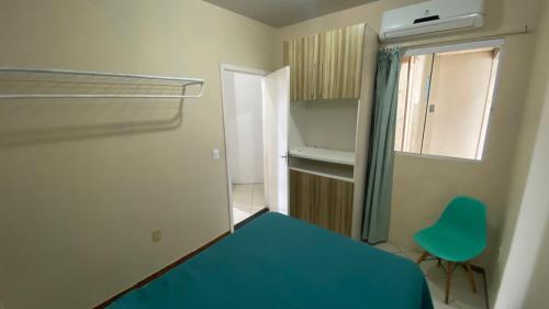 una piccola camera da letto con un letto blu e una finestra di Apartment in Balneário Camboriú a Balneário Camboriú