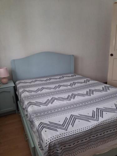 a bed with a black and white comforter on it at A few steps from the beach in Pereybere