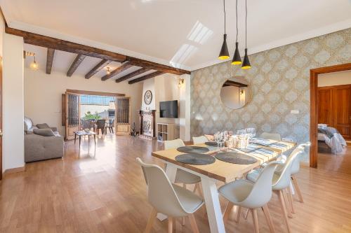 a dining room and living room with a table and chairs at Sueños De La Vega in Las Gabias