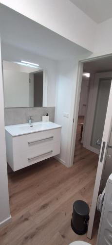 een badkamer met een witte wastafel en een spiegel bij Casa vacanza del Cavallo in Senigallia