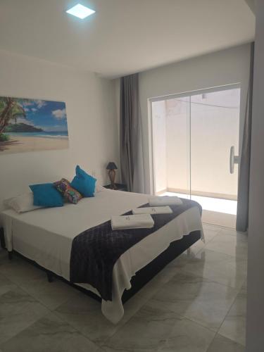 a bedroom with a large bed with a large window at Oceano Residence in Búzios
