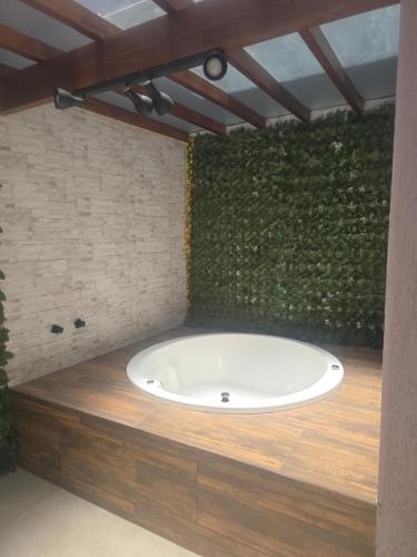 a bath tub in a room with a green wall at Oceano Residence in Búzios