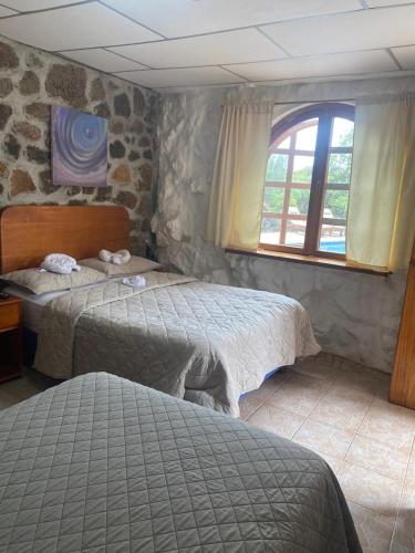 a bedroom with two beds and a window at La Fortaleza De Haro in Puerto Ayora