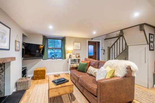 a living room with a couch and a tv at Crossroads Cottage in Drumnadrochit