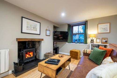a living room with a couch and a fireplace at Crossroads Cottage in Drumnadrochit