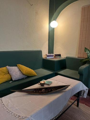 a living room with a green couch and a table at Olivo Hostel, Punta Zicatela in Puerto Escondido