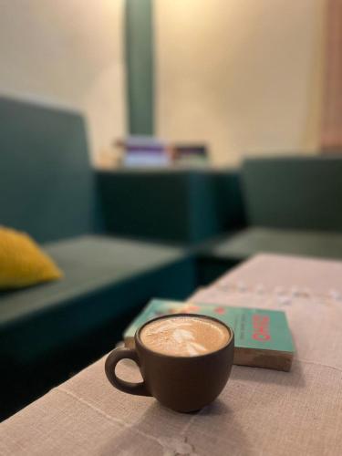 a cup of coffee sitting on top of a table at Olivo Hostel, Punta Zicatela in Puerto Escondido