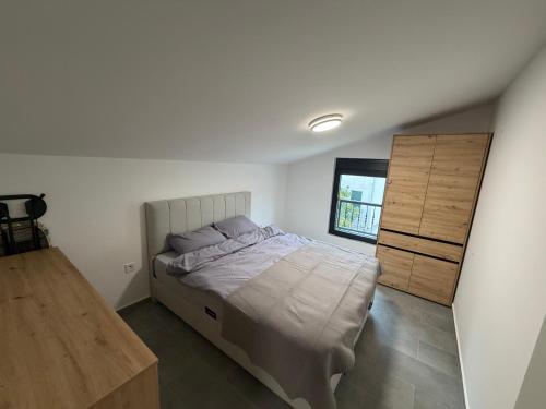 a bedroom with a large bed and a wooden cabinet at Apartments Svetlana, Igalo in Herceg-Novi