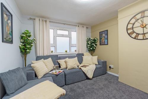 a living room with a blue couch and a clock at Open Mind Property- Hot Tub, Sleeps 9 & Free Parking in Portsmouth