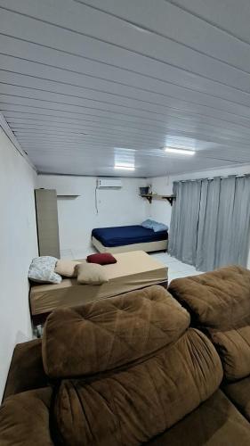 una camera con due letti e un divano in esso di Casa do Rabelo a Balneário Gaivotas