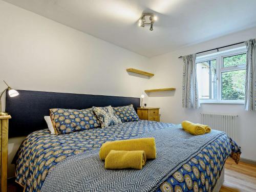 een slaapkamer met een groot bed met gele kussens bij 6 Bed in Lechlade 93251 in Lechlade
