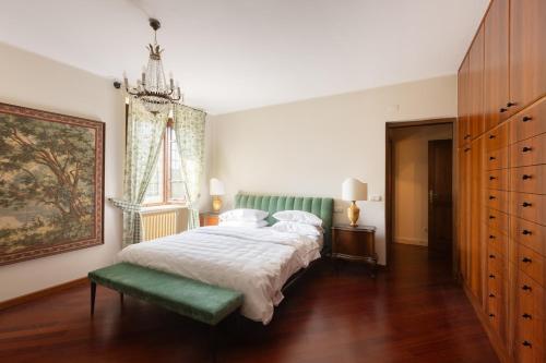a bedroom with a large bed and a green bench at Villa Sant 'Angelus in Canonica