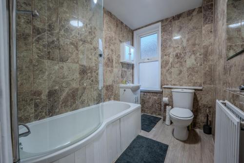 a bathroom with a tub and a toilet and a sink at The Salty Seagull in Scarborough
