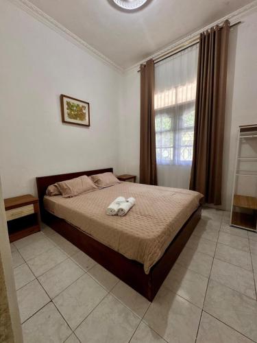 a bedroom with a bed with two towels on it at Omah Putih Jogja in Yogyakarta