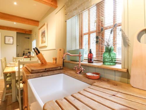 a kitchen with a white sink and a window at The Hayloft - Beautiful Barn Stay in Ashford