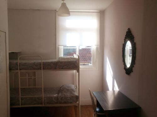 a room with two bunk beds and a window at Duas Nações Guest House in Porto