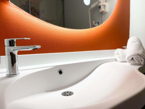 a bathroom sink with a large mirror above it at ibis budget Carcassonne La Cité in Carcassonne