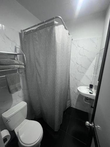 une salle de bains avec douche, toilettes et lavabo dans l'établissement La Posada de Chango, à La Merced