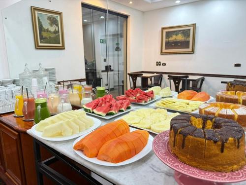 a table filled with lots of different types of food at Hotel Golden Star in Curitiba