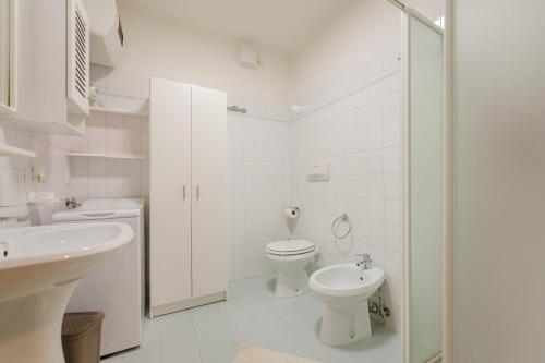 une salle de bains blanche avec toilettes et lavabo dans l'établissement Sasso Bianco Home - Mountain View & Private Parking, à Sottoguda