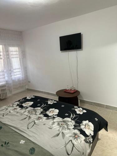 a bedroom with a bed with a floral comforter at Studio Relax2 in Bacău