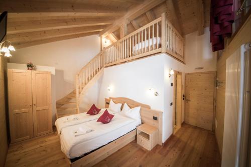 ein Schlafzimmer mit einem großen Bett und einer Treppe in der Unterkunft Maso Fior di Bosco - Val di Rabbi - Esercizio Rurale in Rabbi