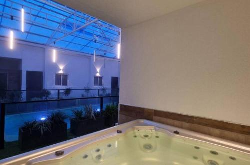 a bath tub in a room with a large window at Don Leon Boutique in Even Menahem