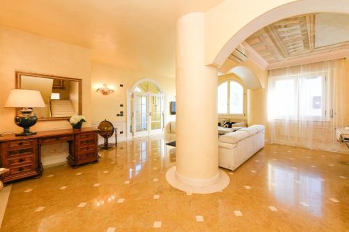 een woonkamer met een zuil en een bank bij Villa Bugatti DesenzanoLoft Official Partner Homes & Villas by Marriott Bonvoy in Desenzano del Garda