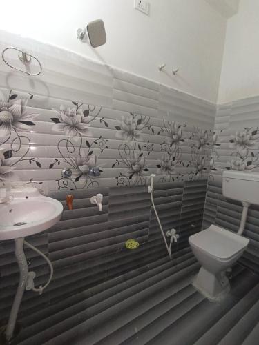 een badkamer met een wastafel en een toilet bij Om guest house in Jasidih