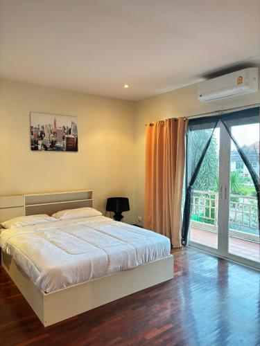 a bedroom with a bed and a large window at NS Private Pool villa in Ban Na Kok