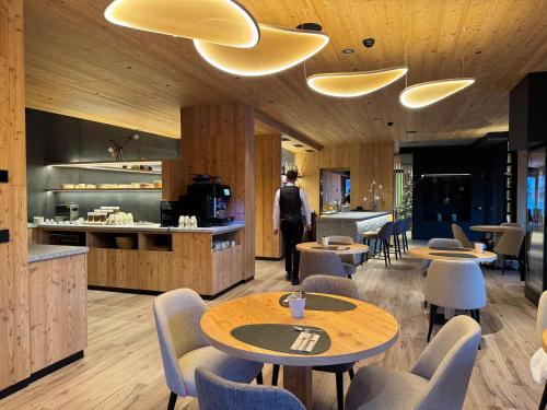 ein Restaurant mit Holzböden und Tischen und Stühlen in der Unterkunft Hotel Damelis in Livigno