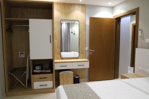a hotel room with a bed and a mirror at اجنحة نزيل & اجنحة الشمال in Tabuk