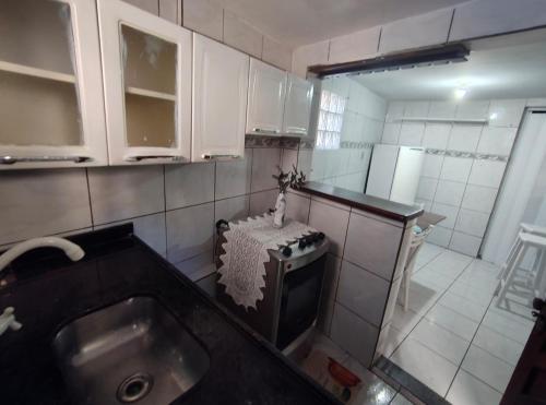 een kleine keuken met een spoelbak en een fornuis bij Jully's house in Arraial do Cabo