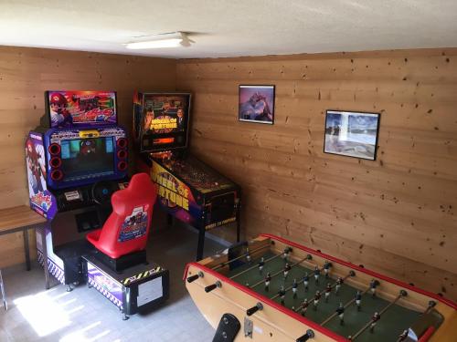 a room with two arcade games and a pool table at Camping L'Oustalet in Châtel