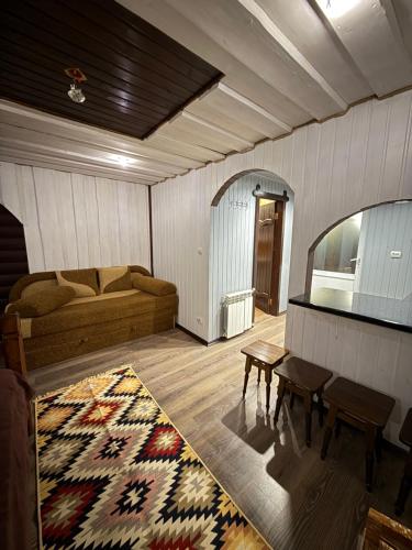 een woonkamer met een bank, een tafel en een tapijt bij У Віти номер 5 in Synevyrsʼka Polyana