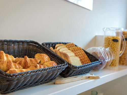 zwei Körbe Brot und Gebäck auf einem Regal in der Unterkunft ibis budget Perpignan Centre Rénové en 2025 - Hôtel Economique au Centre ville de Perpignan in Perpignan